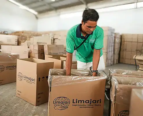 Warehouse worker organizing and packing boxes at Limajari Cargo logistics facility, showcasing efficient cargo handling and storage solutions.