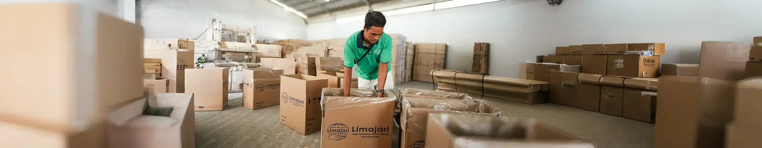 Limajari Cargo Warehouse Operations Warehouse worker organizing and packing boxes at Limajari Cargo logistics facility, showcasing efficient cargo handling and storage solutions.
