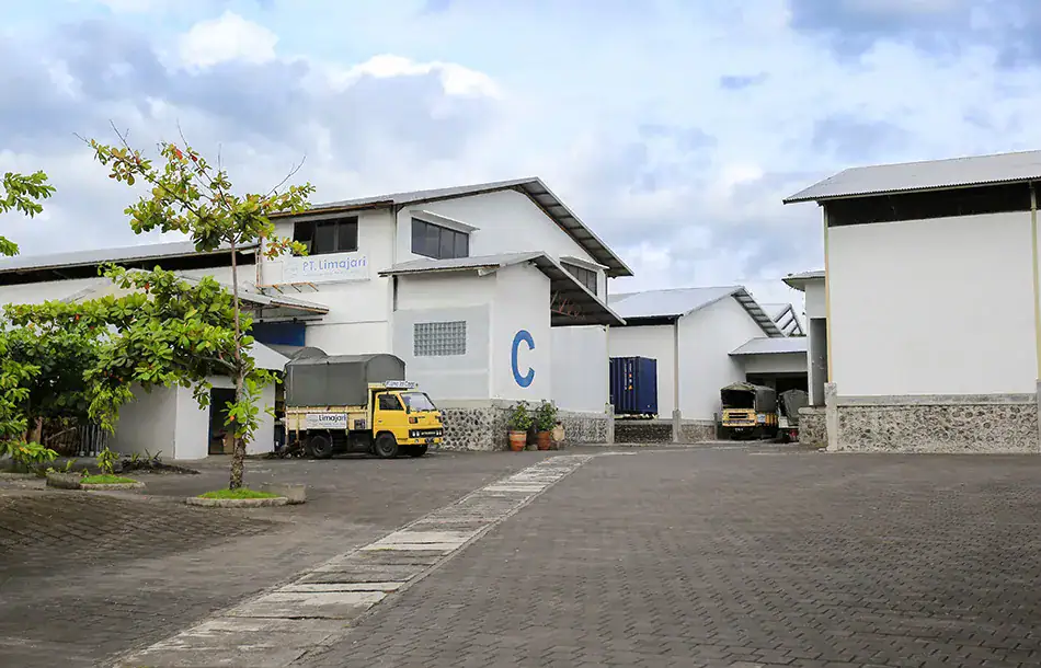 Limajari Cargo warehouse with trucks parked outside, showcasing logistics and freight services in a modern industrial setting.