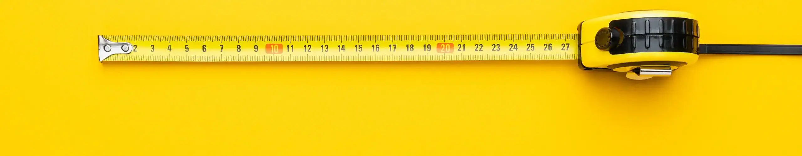 Close-up of a measuring tape from Limajari Cargo on a bright yellow background, emphasizing precision and logistics services.