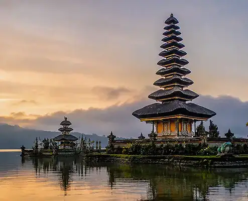 Temple balinais traditionnel au bord de l'eau au coucher du soleil, représentant le patrimoine culturel et la signification spirituelle. Temple balinais au bord de l'eau au coucher du soleil, mettant en valeur le patrimoine culturel et la tranquillité spirituelle.