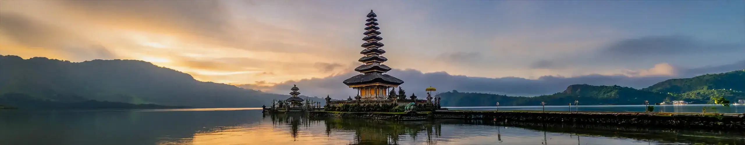 Balinese temple by the water at sunset, showcasing cultural heritage and spiritual tranquility.