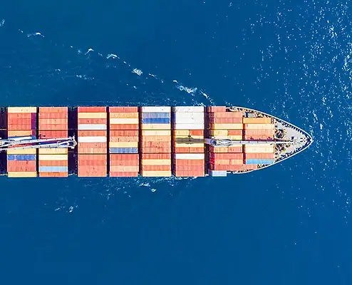 Navire cargo naviguant sur l’océan avec des conteneurs sur le pont Un navire cargo naviguant en pleine mer, chargé de conteneurs colorés, représentant un transport de fret efficace et des services logistiques mondiaux.