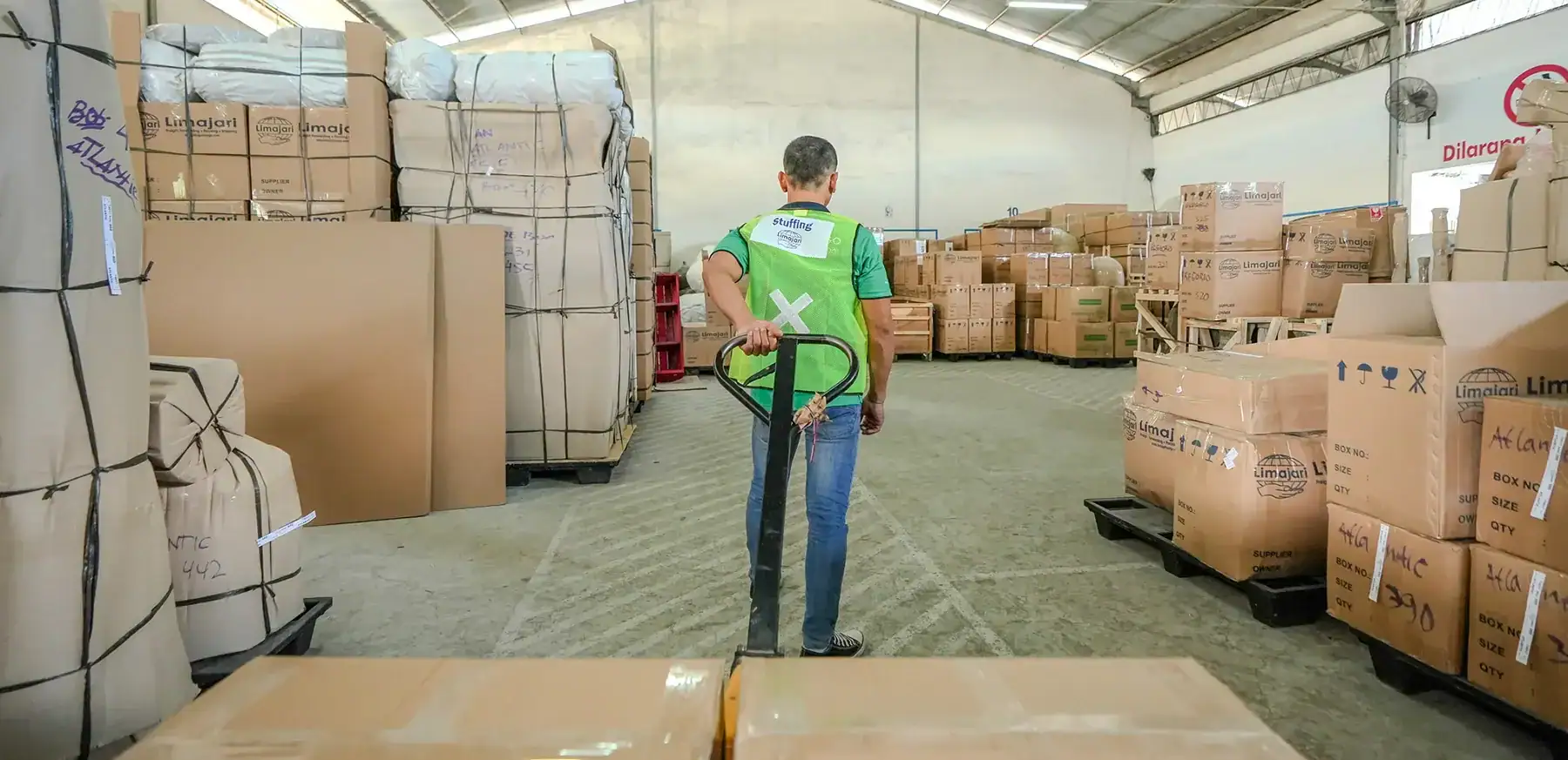 Warehouse worker managing cargo and packages at Limajari Cargo logistics center, ensuring efficient storage and transportation of goods.