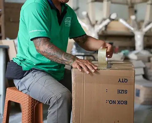 Emballage et expédition dans l’entrepôt de Limajari Cargo, illustrant une manutention efficace des colis avec ruban adhésif et cartons pour des services logistiques fiables.